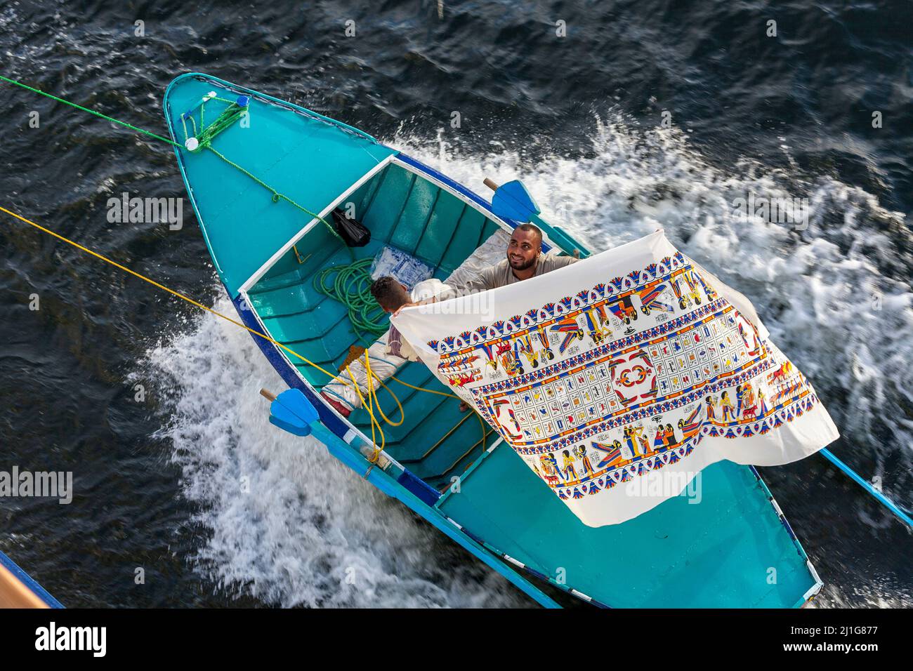 Les commerçants locaux se plaisent sur leurs marchandises à partir d'un bateau attaché à un bateau de croisière sur le Nil Banque D'Images