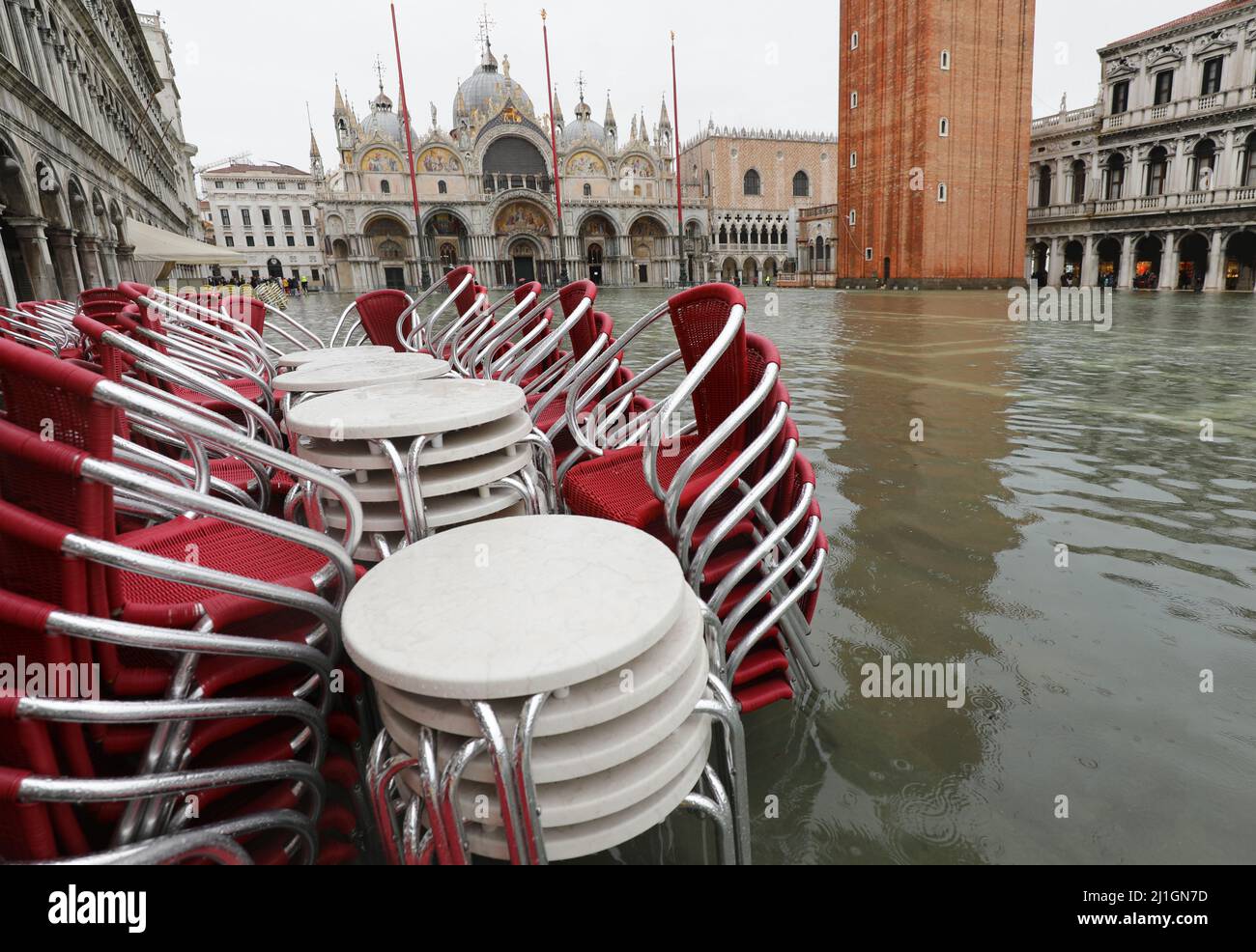 Chaises et tables d'un bar en plein air sur la place Saint-Marc à Venise en Italie lors de l'inondation avec la haute eau due au changement climatique Banque D'Images