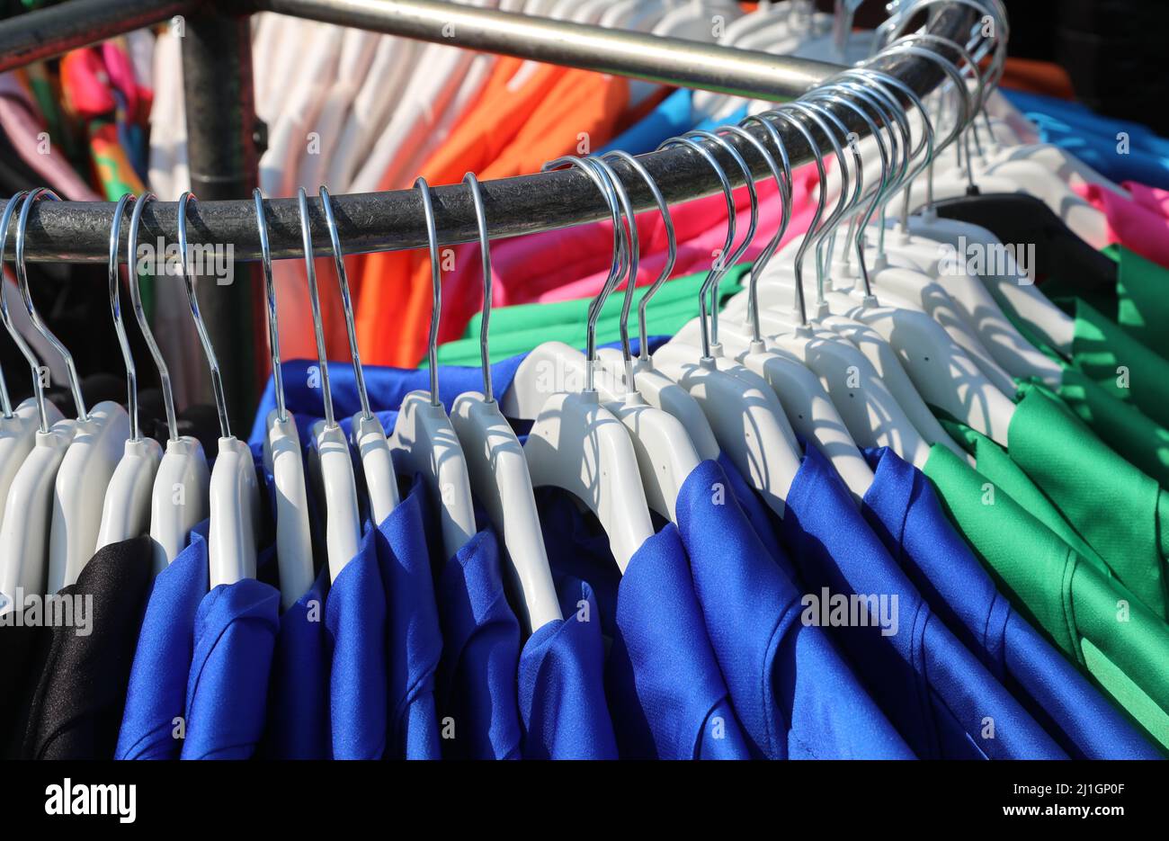 vêtements et tabliers bleus pour la maternelle et l'école primaire suspendus sur la porte-manteau dans une cabine de vêtements à la mode Banque D'Images