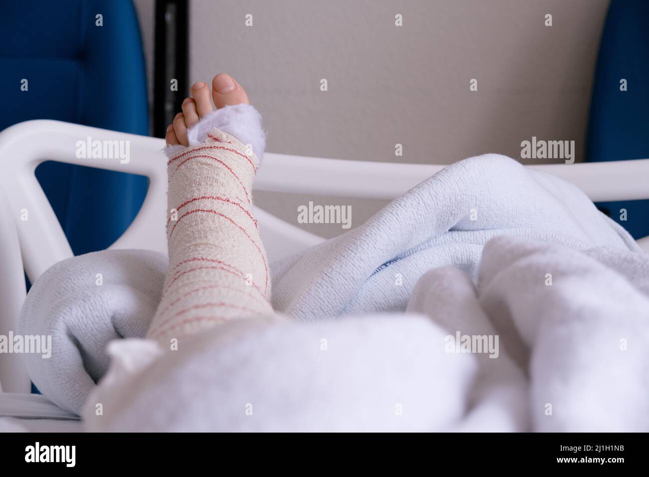 Personne méconnaissable avec un bandage de jambe se reposant dans une clinique médicale Banque D'Images