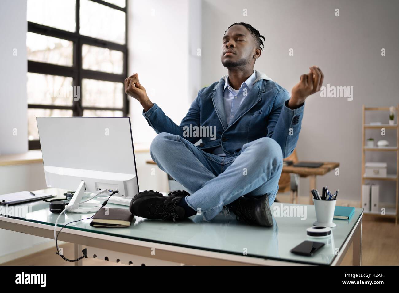 Un employé africain faisant de la santé mentale Yoga Méditation en bureau Banque D'Images