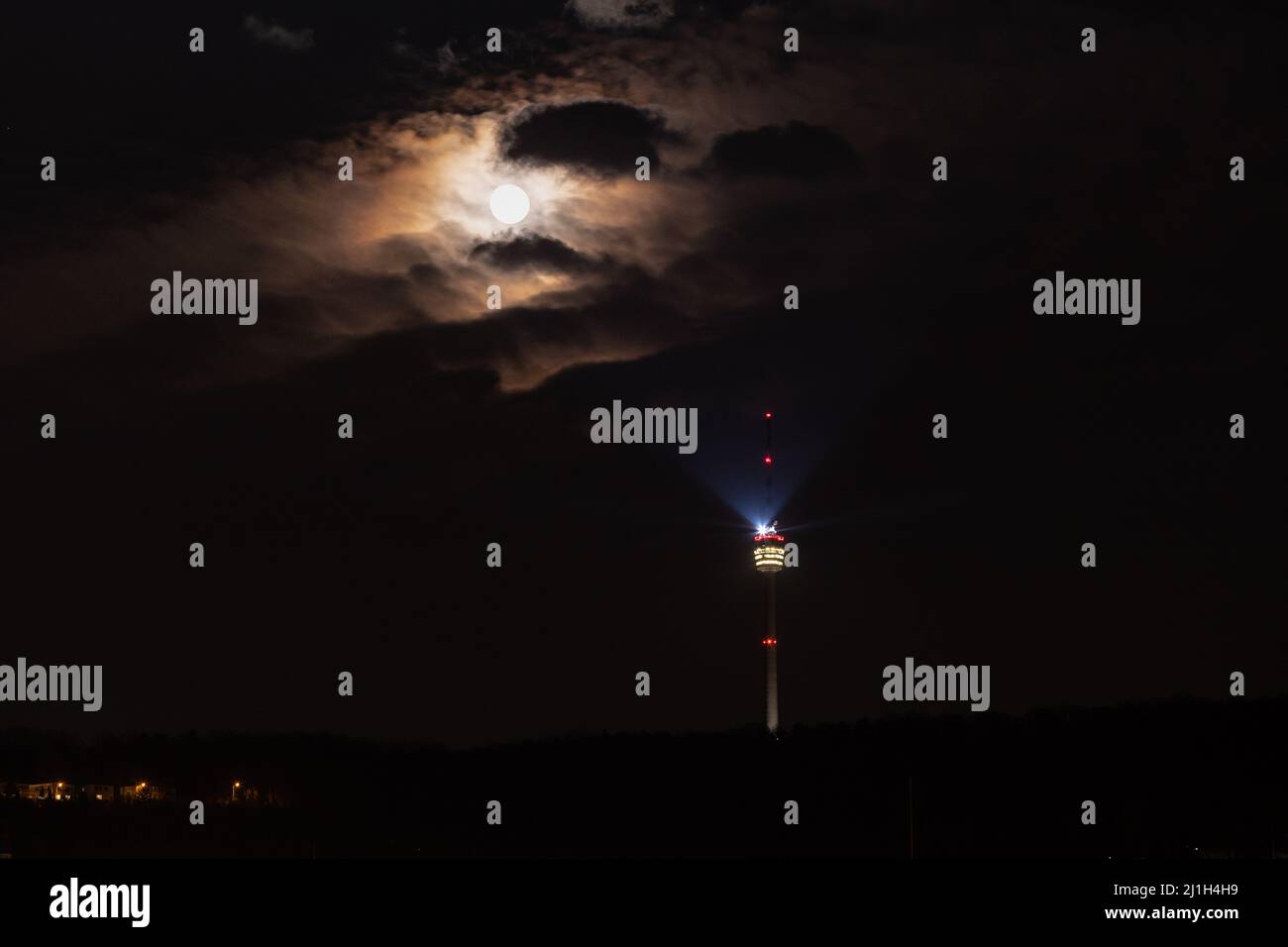 Tour de télévision de Stuttgart la nuit, pleine lune qui brille à travers le ciel nuageux, marqueurs de position rouges et faisceau lumineux lumineux lumineux Banque D'Images