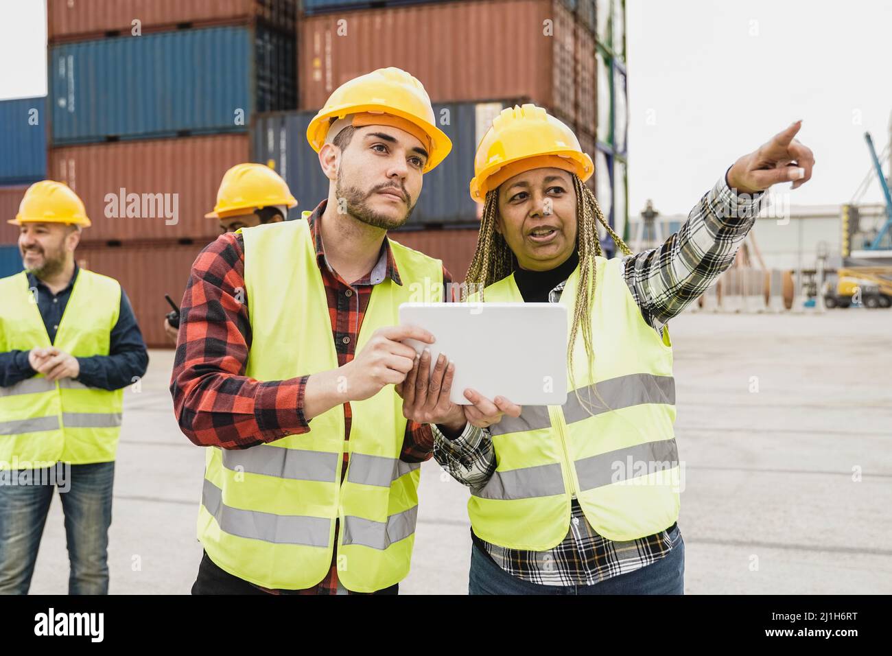 Opérateurs industriels multiraciaux travaillant au terminal de logistique de fret de conteneurs - Focus sur le visage de l'homme Banque D'Images Opérateurs industriels multiraciaux travaillant au terminal de logistique de fret de conteneurs - Focus sur le visage de l'homme Banque D'Images