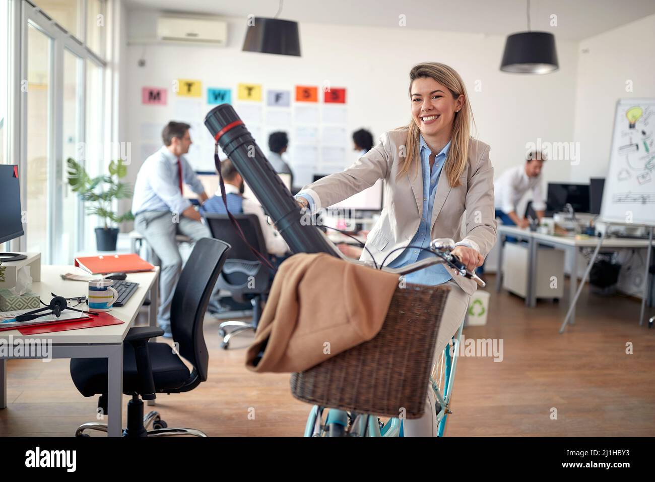 Une jeune employée gaie aime poser pour une photo tout en faisant du vélo dans une atmosphère détendue pendant une pause au bureau. Employés, poste, o Banque D'Images
