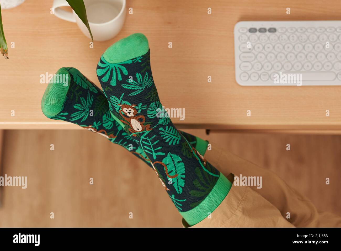 Vue de dessus des pieds avec des chaussettes drôles sur un bureau Banque D'Images