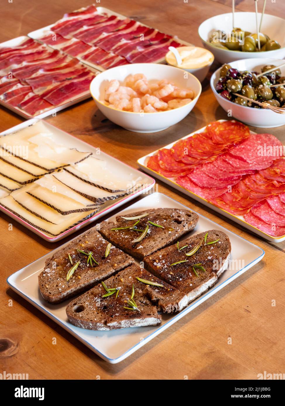 Tapas espagnoles mélangées sur une table avec pain de Pa amb oli à l'huile, fromage de manchego et chorizo Banque D'Images