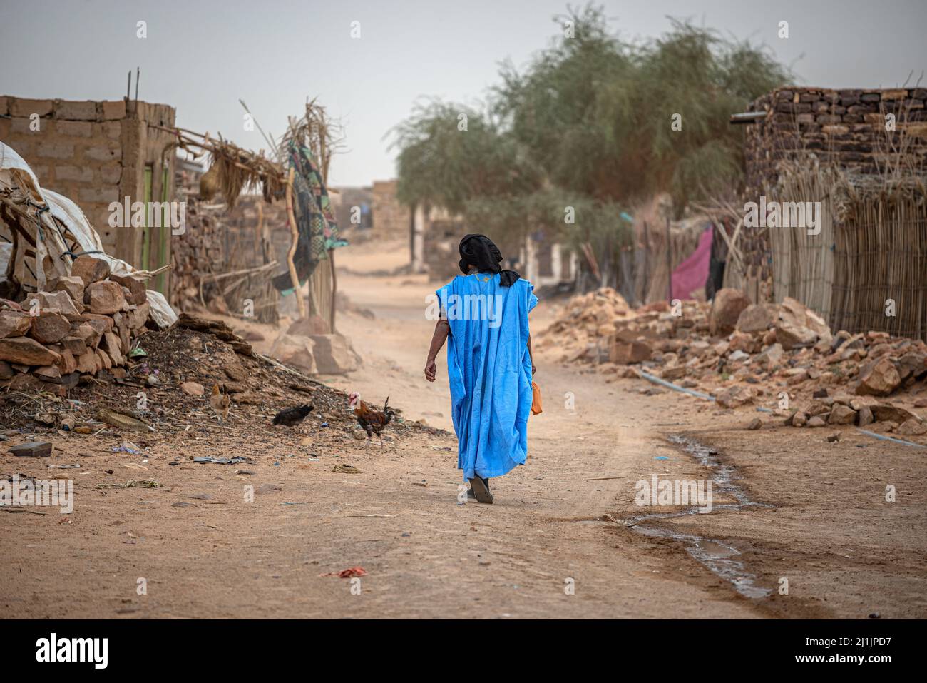 Homme mauritanien avec un boubou bleu et un turban sombre dans les rues de Toungat, en Mauritanie Banque D'Images