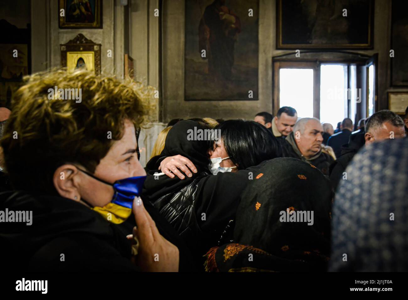 Tbilissi, Géorgie. 25th mars 2022. Les parents et les amis tentent de réconforter la mère du soldat pendant les funérailles. Une cérémonie d'adieu a eu lieu pour David Beriashvili, un soldat tué par balle pour la défense de l'Ukraine contre l'attaque russe, la cérémonie funéraire s'est tenue dans l'église centrale de Tbilissi, en Géorgie, où beaucoup se sont réunis pour soutenir la famille du soldat. Le corps d'un autre soldat (Gia Beriashvili) se trouve dans une autre église. Crédit : SOPA Images Limited/Alamy Live News Banque D'Images