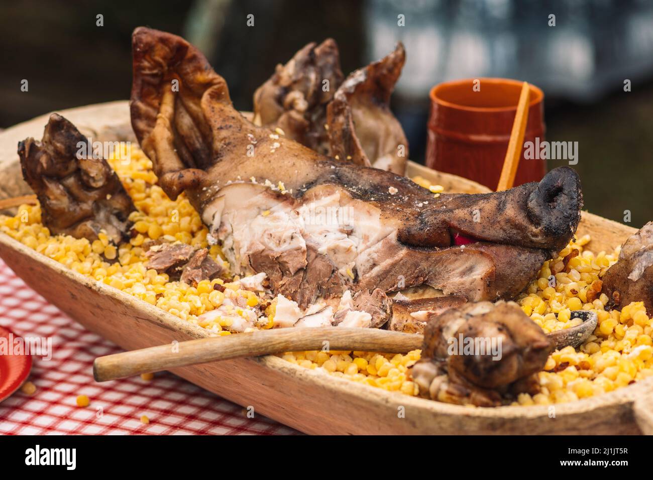 Tête de porc grillée dans une assiette traditionnelle en bois sur une table dans un festival régional de marché de rue Banque D'Images