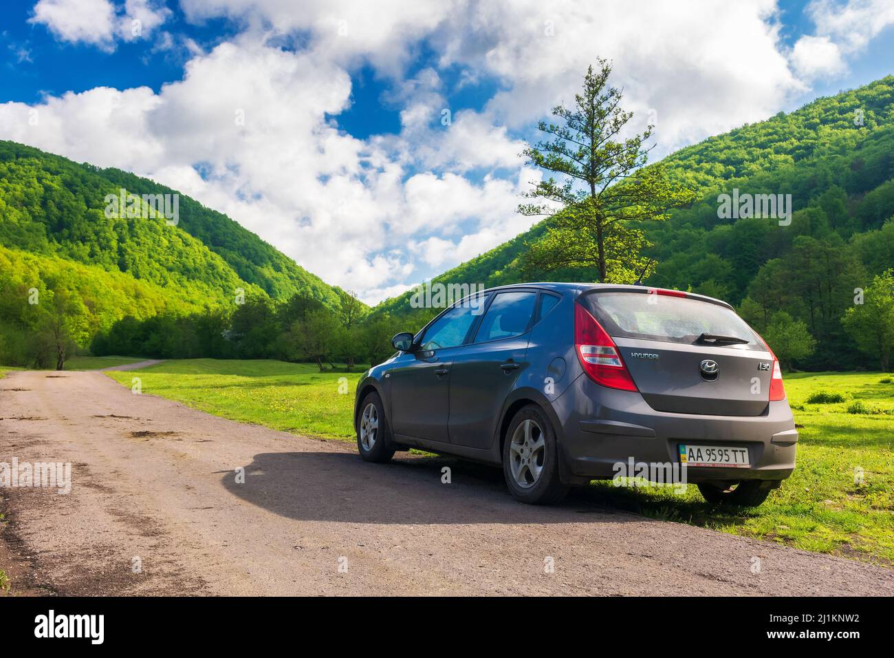 Turya, ukarine - 17 MAI 2021: Voiture sur une route de campagne le matin. Beau paysage dans la vallée rurale le matin ensoleillé. Voyage campagne an Banque D'Images