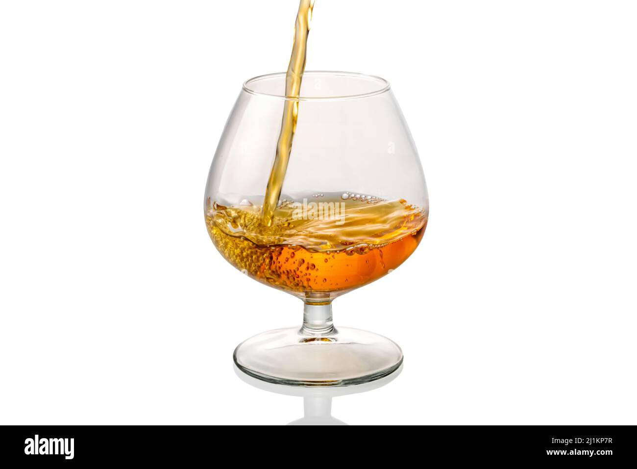 cognac français versé dans un verre isolé sur un chemin de coupure blanc Banque D'Images