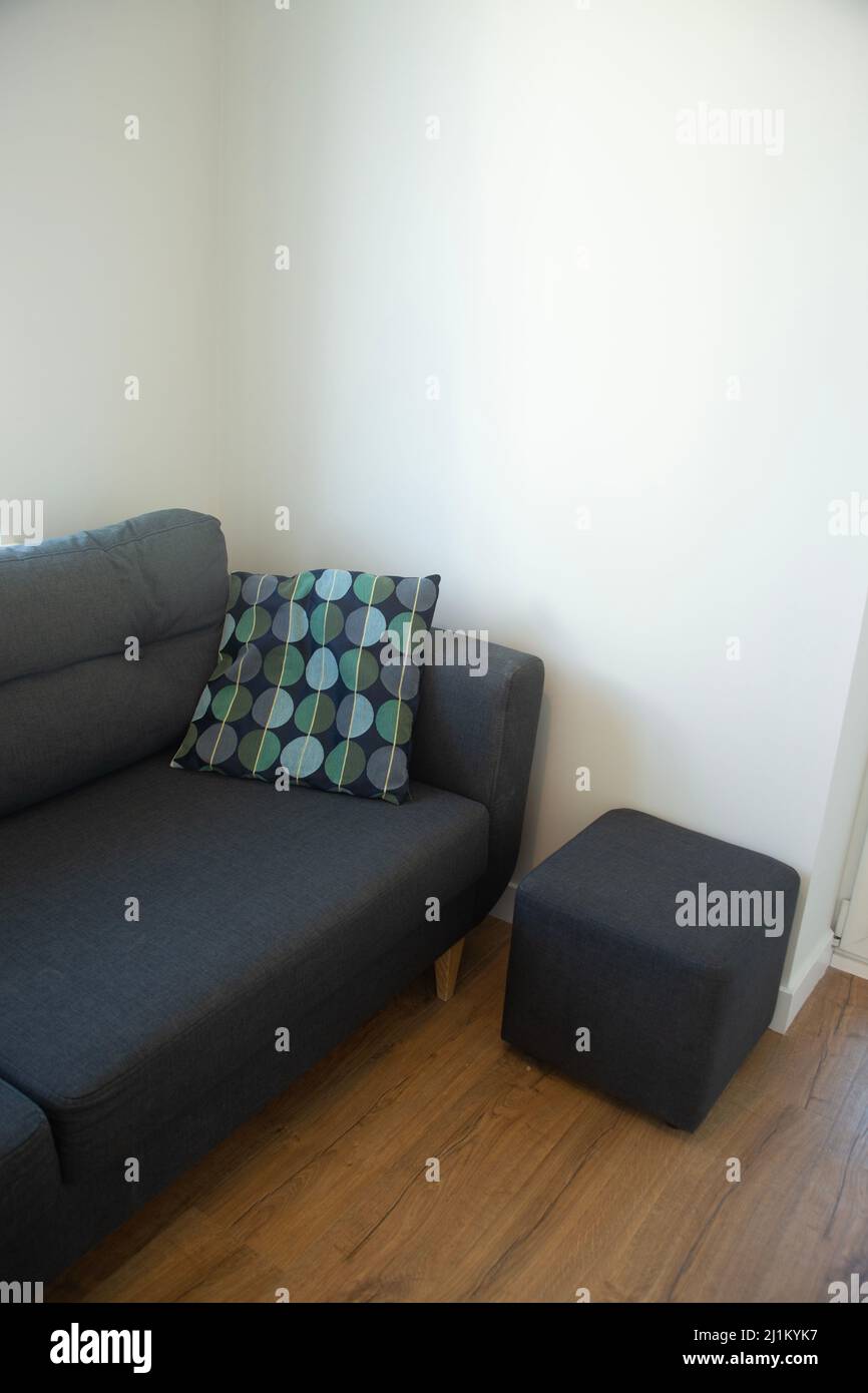 Canapé bleu foncé avec coussin bleu et turquoise dans une pièce blanche Banque D'Images