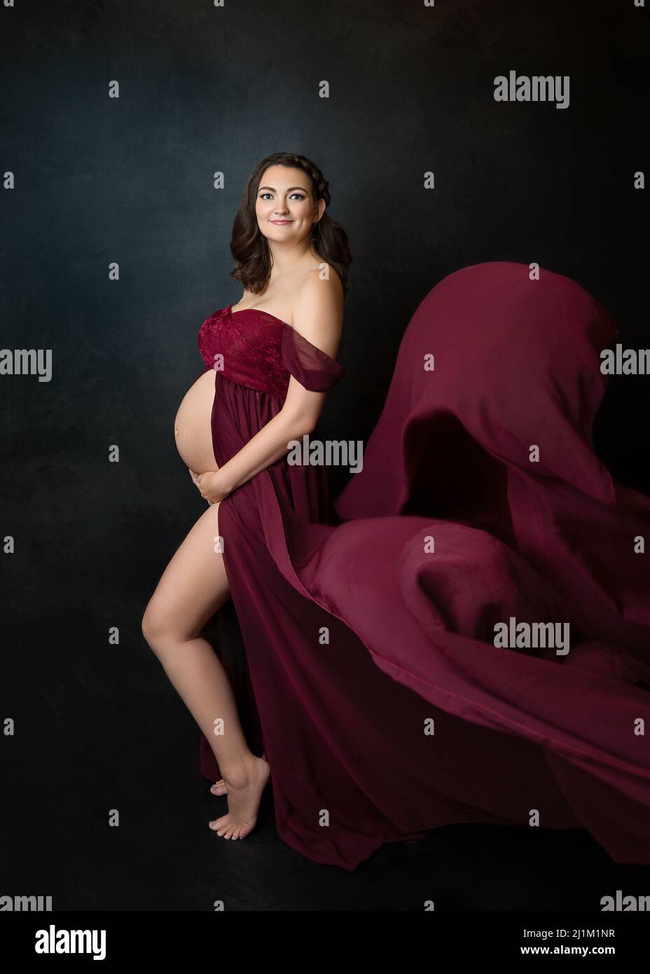 Studio maternité Portrait d'une femme enceinte dans une belle Gwn fluide Banque D'Images