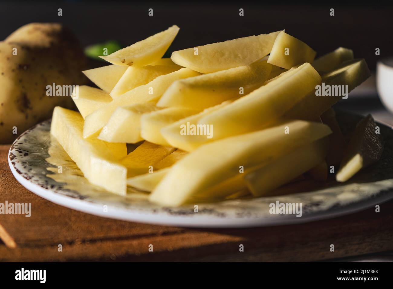 Préparer des frites avec des pommes de terre de canne crues. Vue en gros plan, hachée ou haute. Banque D'Images