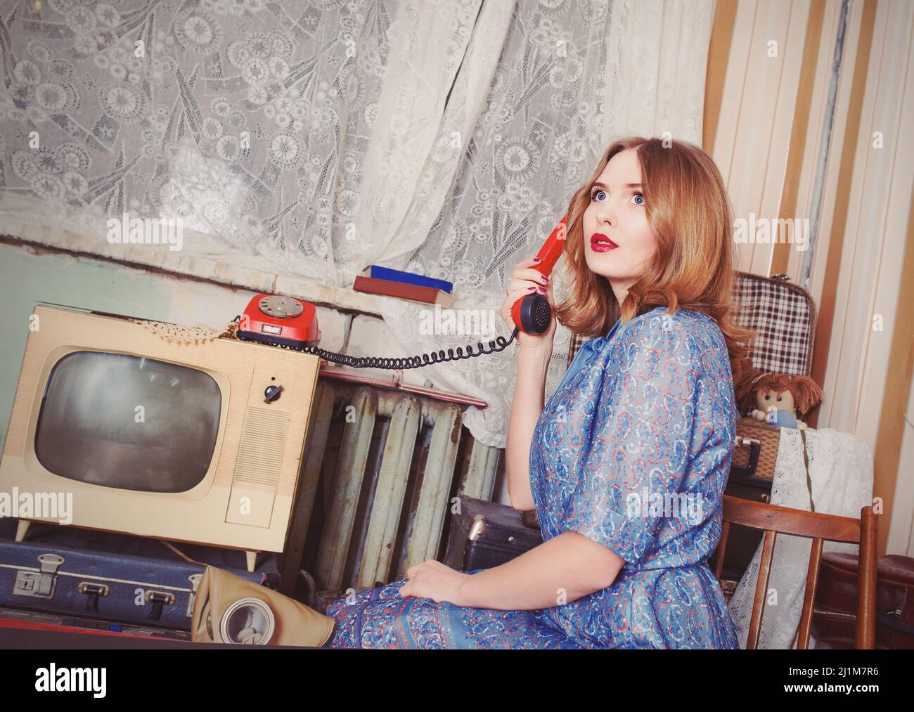 Portrait de la femme à l'ancienne dans le style de l'URSS parlant sur le vieux téléphone dans l'intérieur rétro Banque D'Images