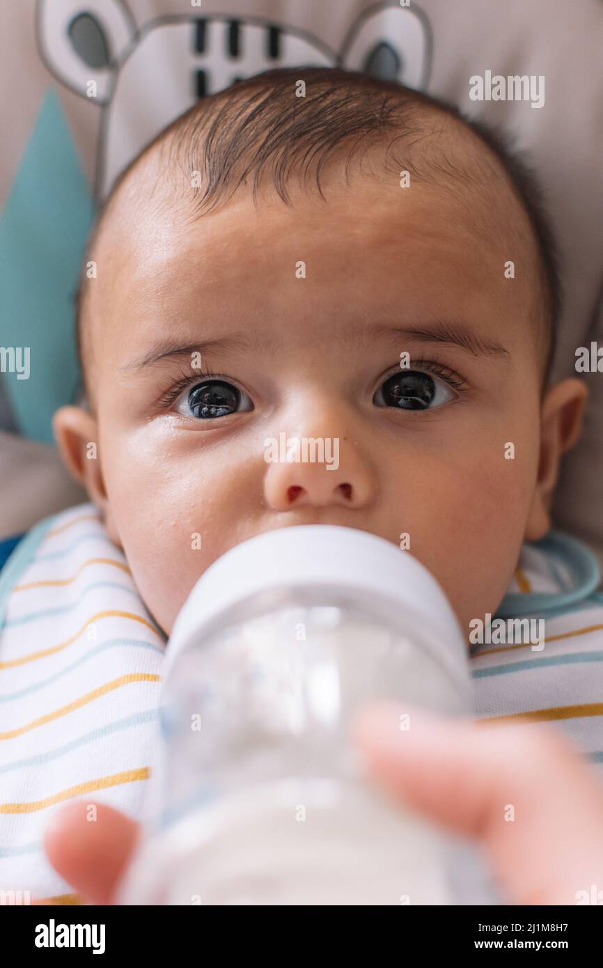 Bébé boit du lait dans un biberon. Banque D'Images
