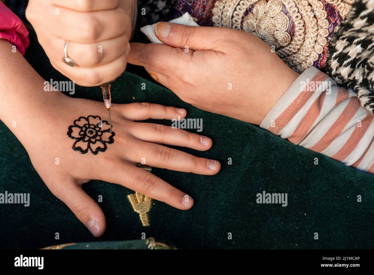 Dessin de henné menhdi tatouage sur les mains de fille dans un marché médiéval. Banque D'Images