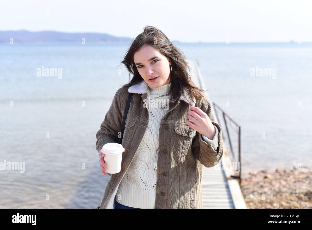 Au printemps, une jeune femme russe boit du café contre la mer japonaise Banque D'Images