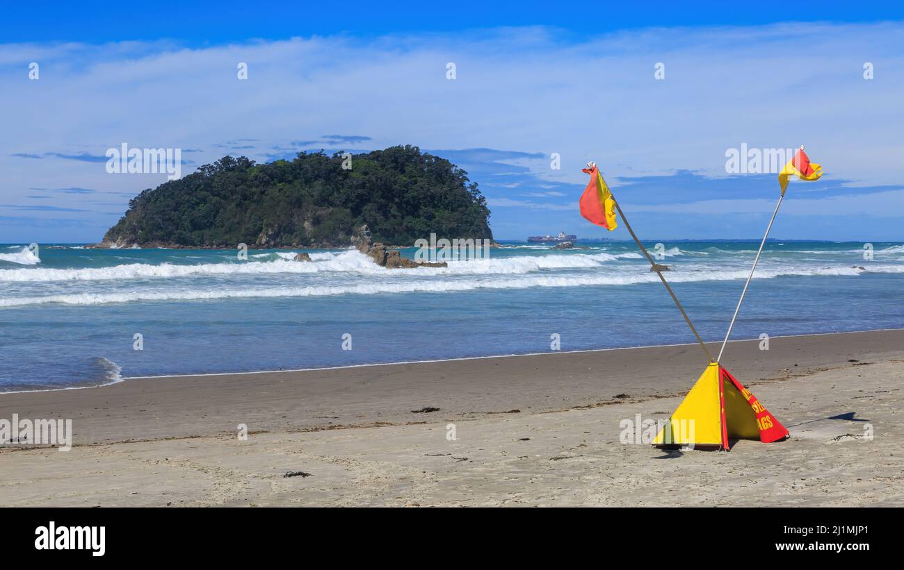 Drapeaux de surf croisés indiquant « ne pas nager » sur la plage. Photographié au Mont Maunganui, Nouvelle-Zélande. Au large de l'île Motuotau Banque D'Images