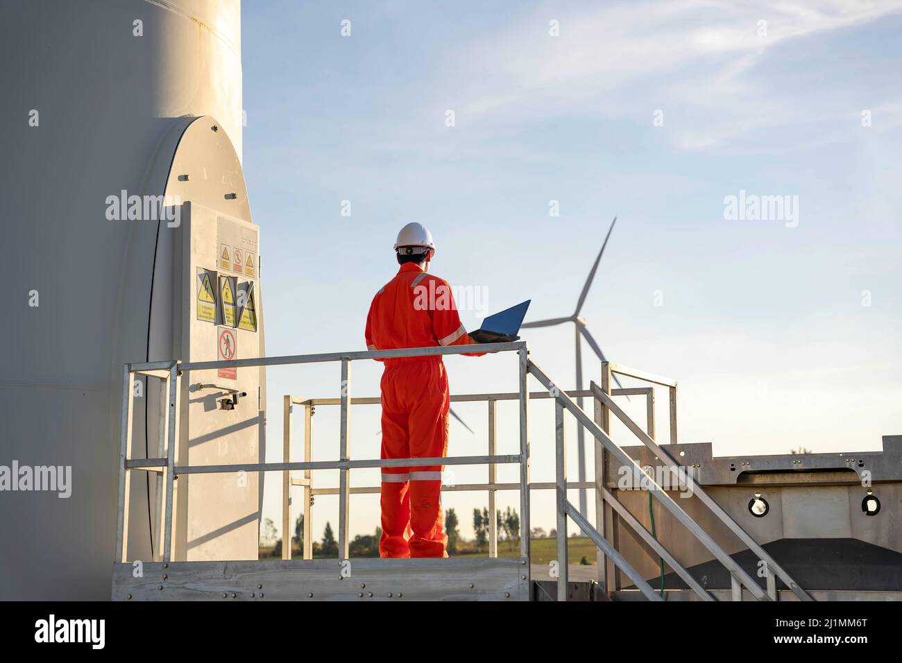 Homme ingénieur travaillant et tenant l'ordinateur portable pour vérifier les performances de la centrale éolienne, concept de ressources durables, Conc Banque D'Images