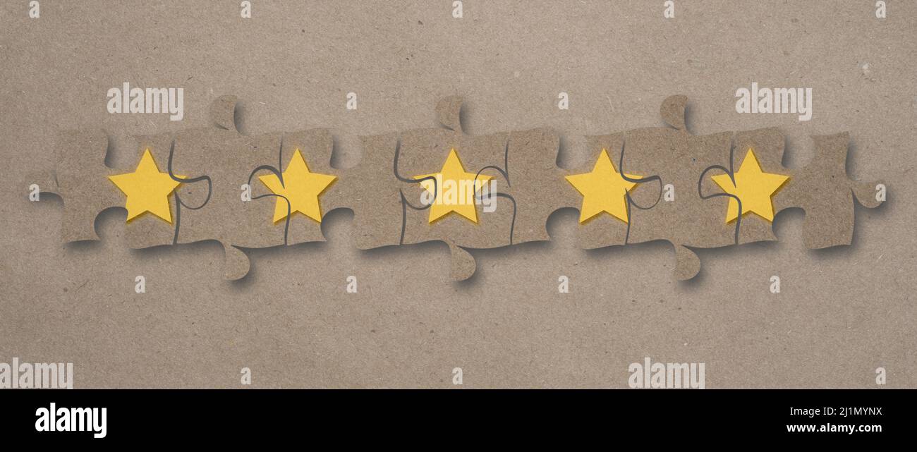 Cinq étoiles assemblées sur des pièces de puzzle sur fond de papier artisanal. Banque D'Images