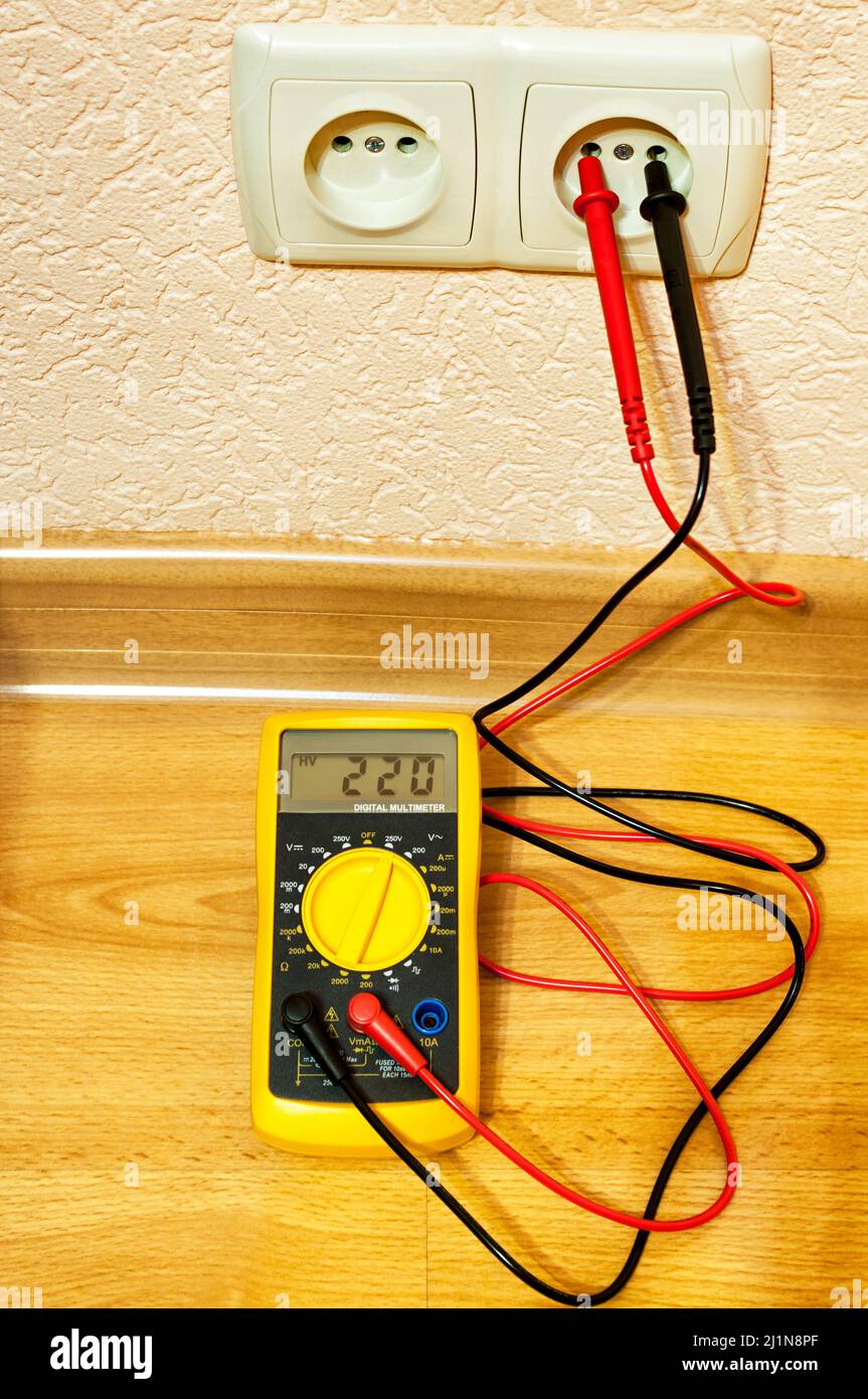 Mesure de la tension de la prise avec un multimètre numérique. Banque D'Images