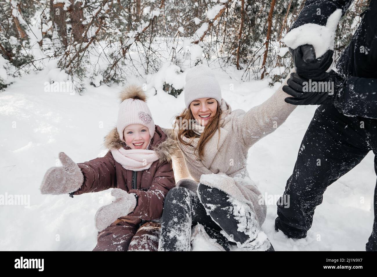 maman et papa joyeux et fille couché dans la neige Banque D'Images
