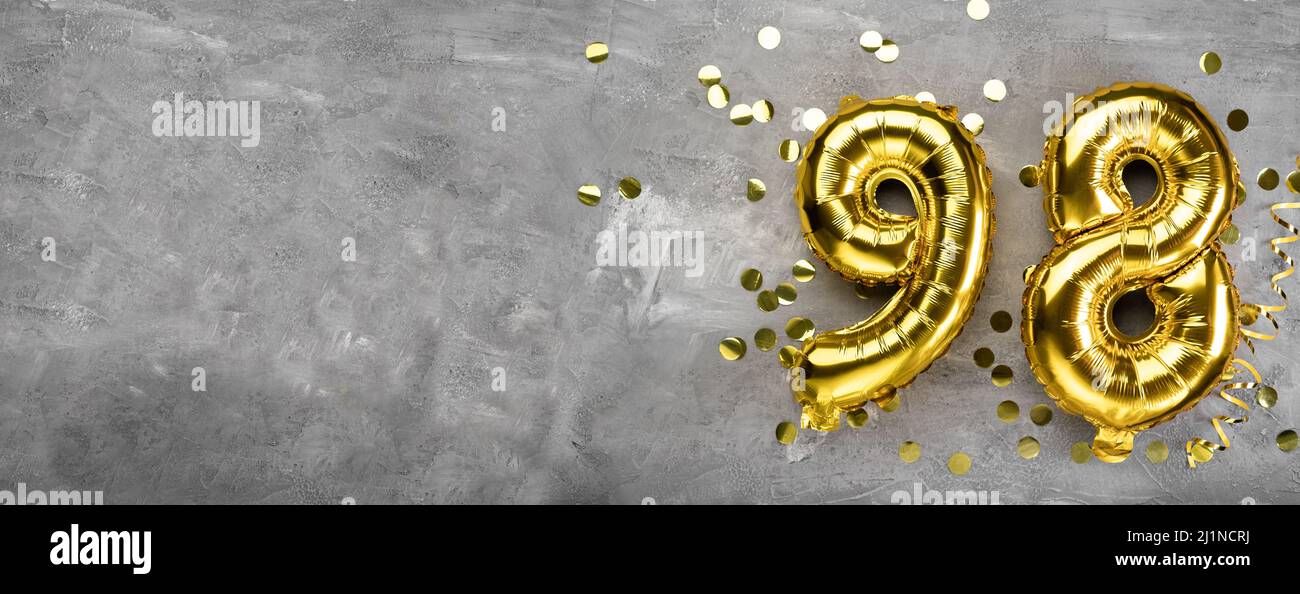 Numéro de ballon de feuille jaune, quatre-vingt-dix-huit sur un fond en béton. Carte de vœux avec inscription 98. Concept anniversaire. Pour anniversaire Banque D'Images