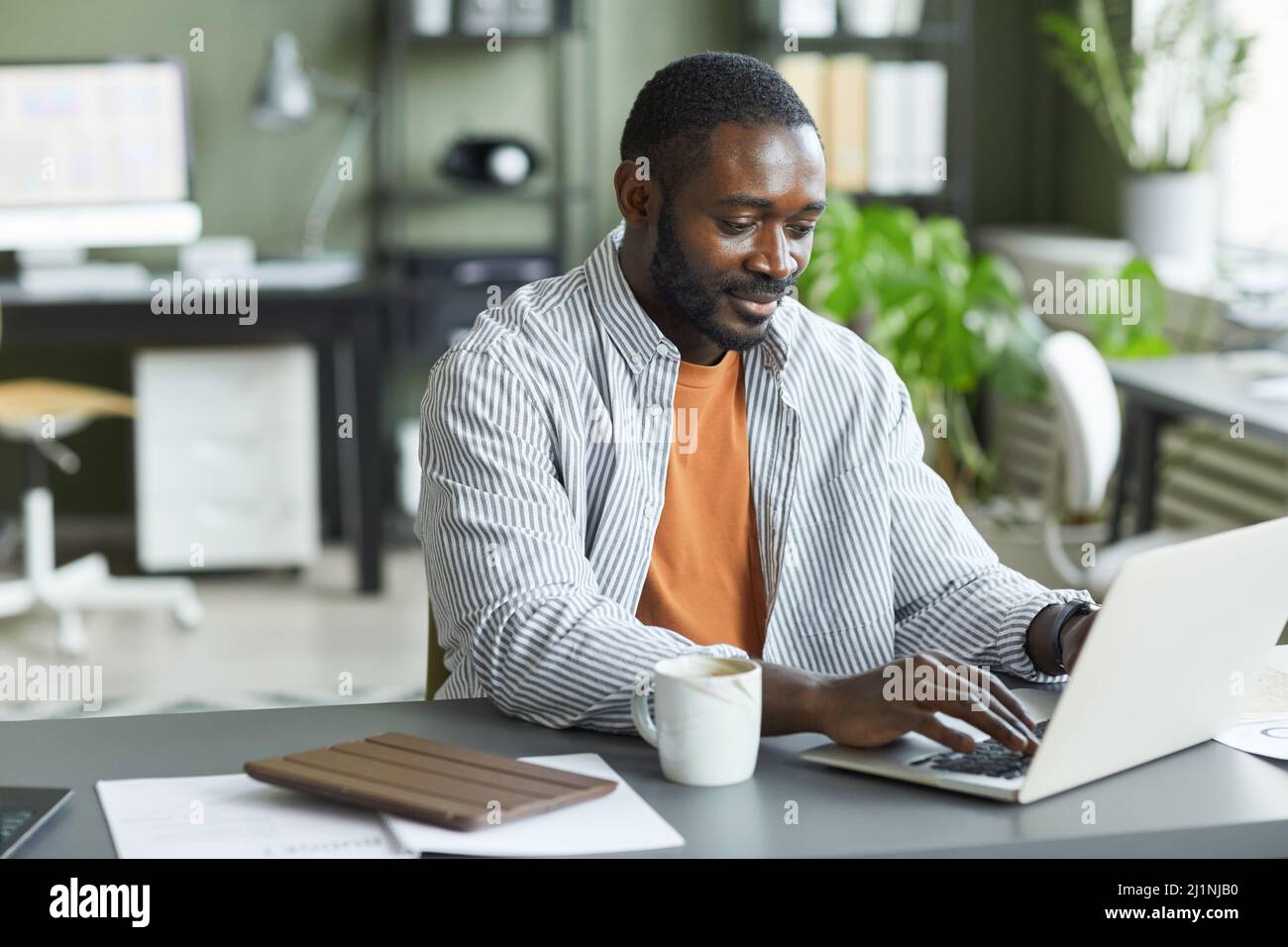 Portrait d'un homme noir adulte travaillant au bureau à domicile et utilisant un ordinateur portable, espace de copie Banque D'Images