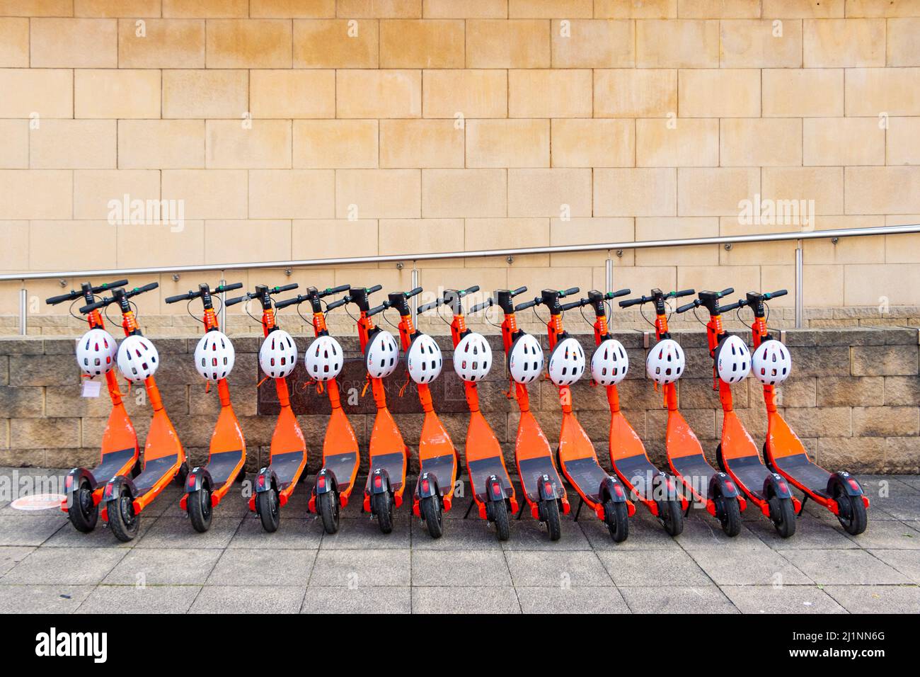 Location de scooters de mobilité Orange Neuron garés dans une rangée à Newcastle on Tyne, Royaume-Uni Banque D'Images
