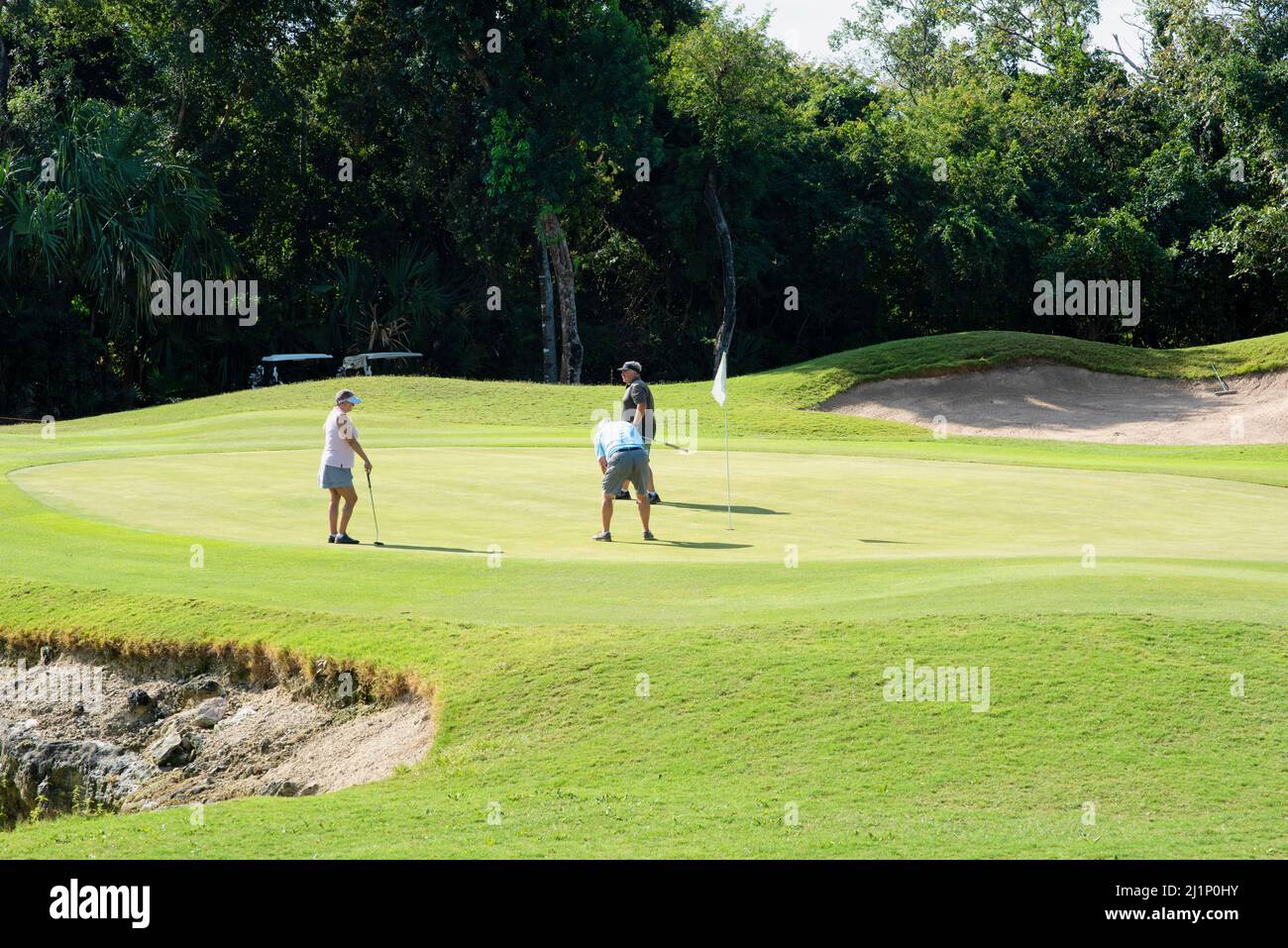 Playa del Carmen, 25th, 2022 mars : trois golfeurs en vert à playa del Carmen au Mexique, un jour d'été Banque D'Images