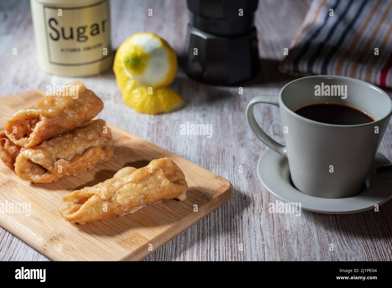 Pestiños à côté d'une tasse de café, avec certains des ingrédients utilisés dans sa préparation. Banque D'Images