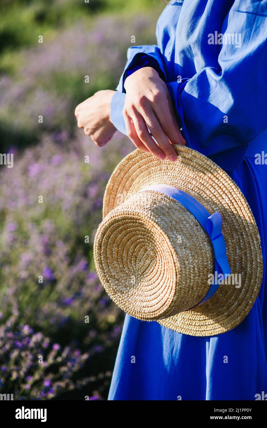 Femme tenant un chapeau de paille avec ruban violet dans les mains. Gros  plan Photo Stock - Alamy
