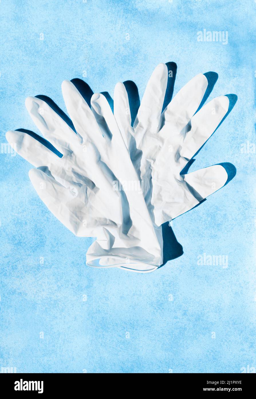 Paire de gants chirurgicaux blancs sur fond bleu , soins de santé et médecine Banque D'Images
