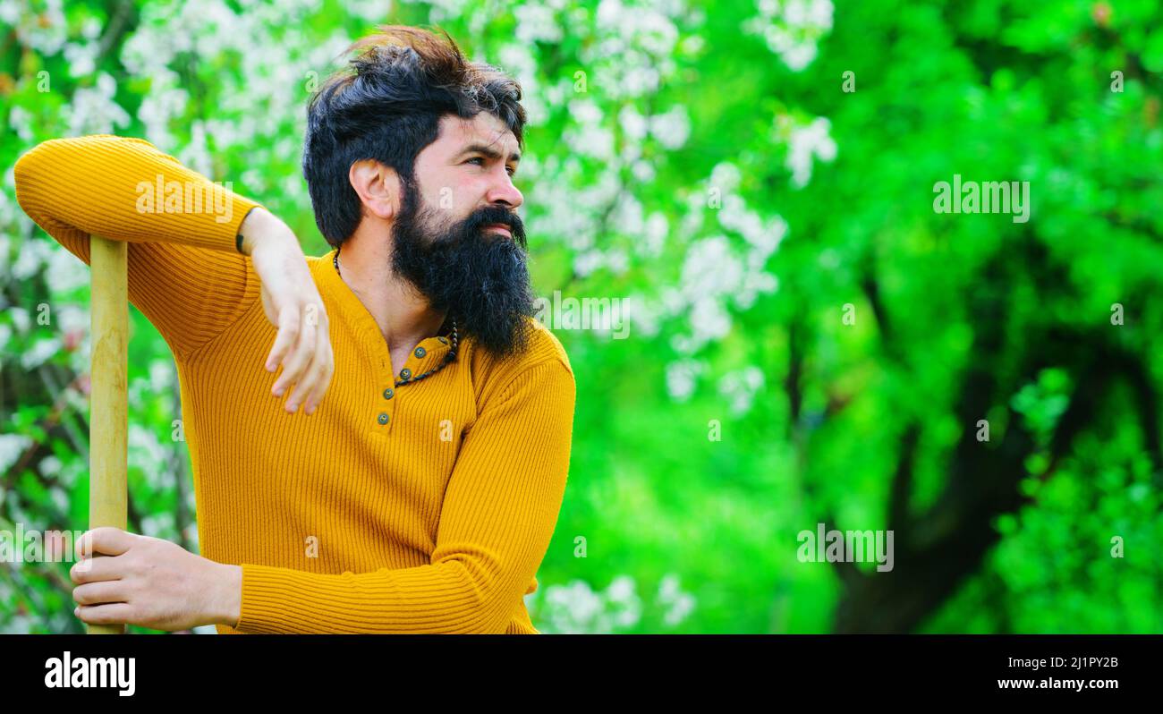 Homme barbu jardinant dans le jardin de l'arrière-cour. Jardinier creusant avec une bêche. Agriculteur avec pelle. Banque D'Images