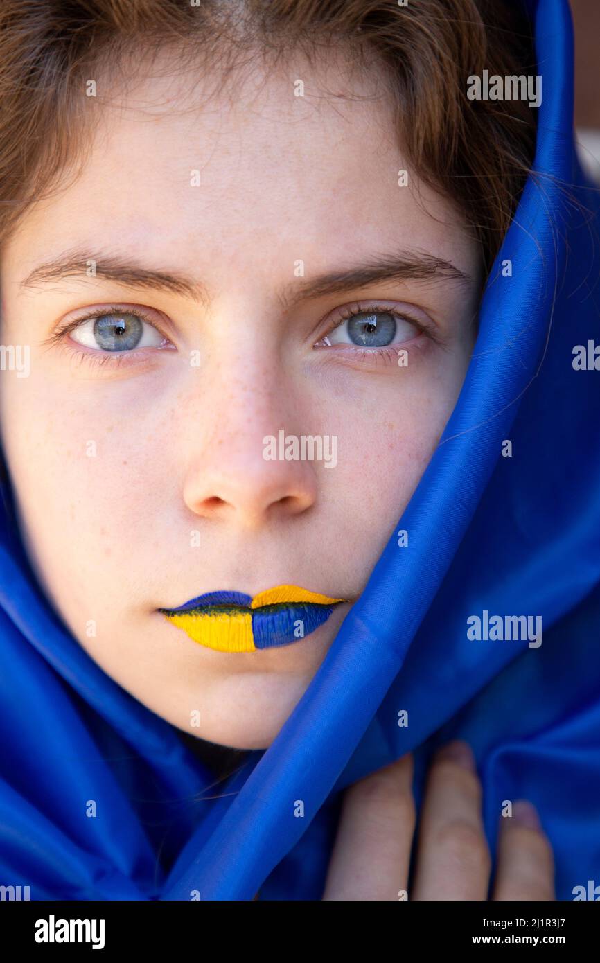 Beau visage d'une jeune femme ukrainienne avec des lèvres peintes jaune-bleu gros plan. Un regard perçant. Arrêter la guerre. Espoir et foi. Soutenir l'Ukraine. Arti Banque D'Images
