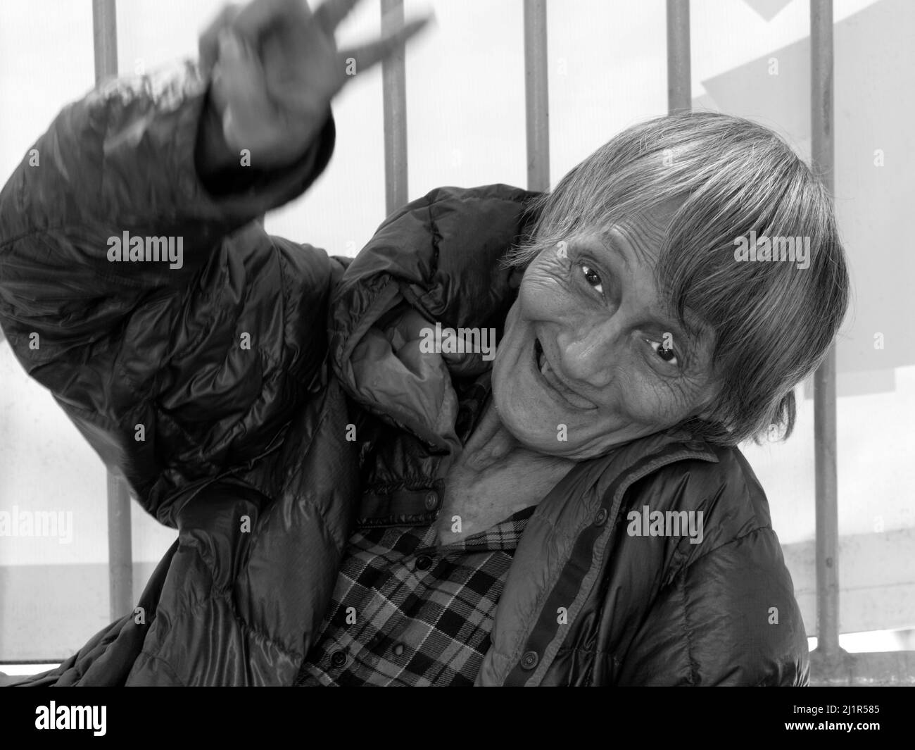La vieille dame a fait sourire à la caméra tout en mendiant dans les rues de Hong Kong. Banque D'Images
