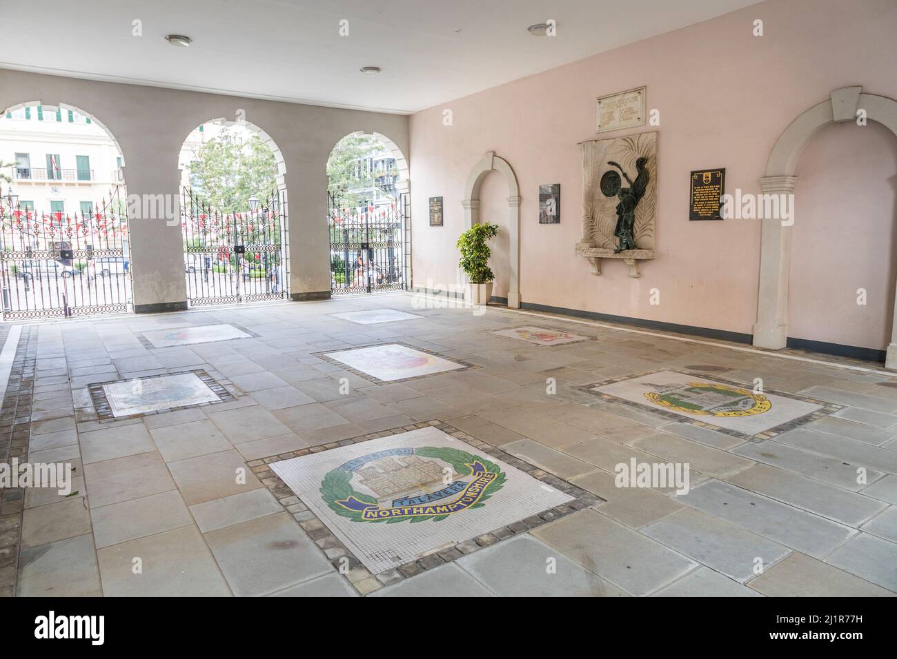 Le monument commémoratif de la Seconde Guerre mondiale est installé dans un mur, Gibraltar, avec des insignes de régiment incrusté dans des carreaux Banque D'Images