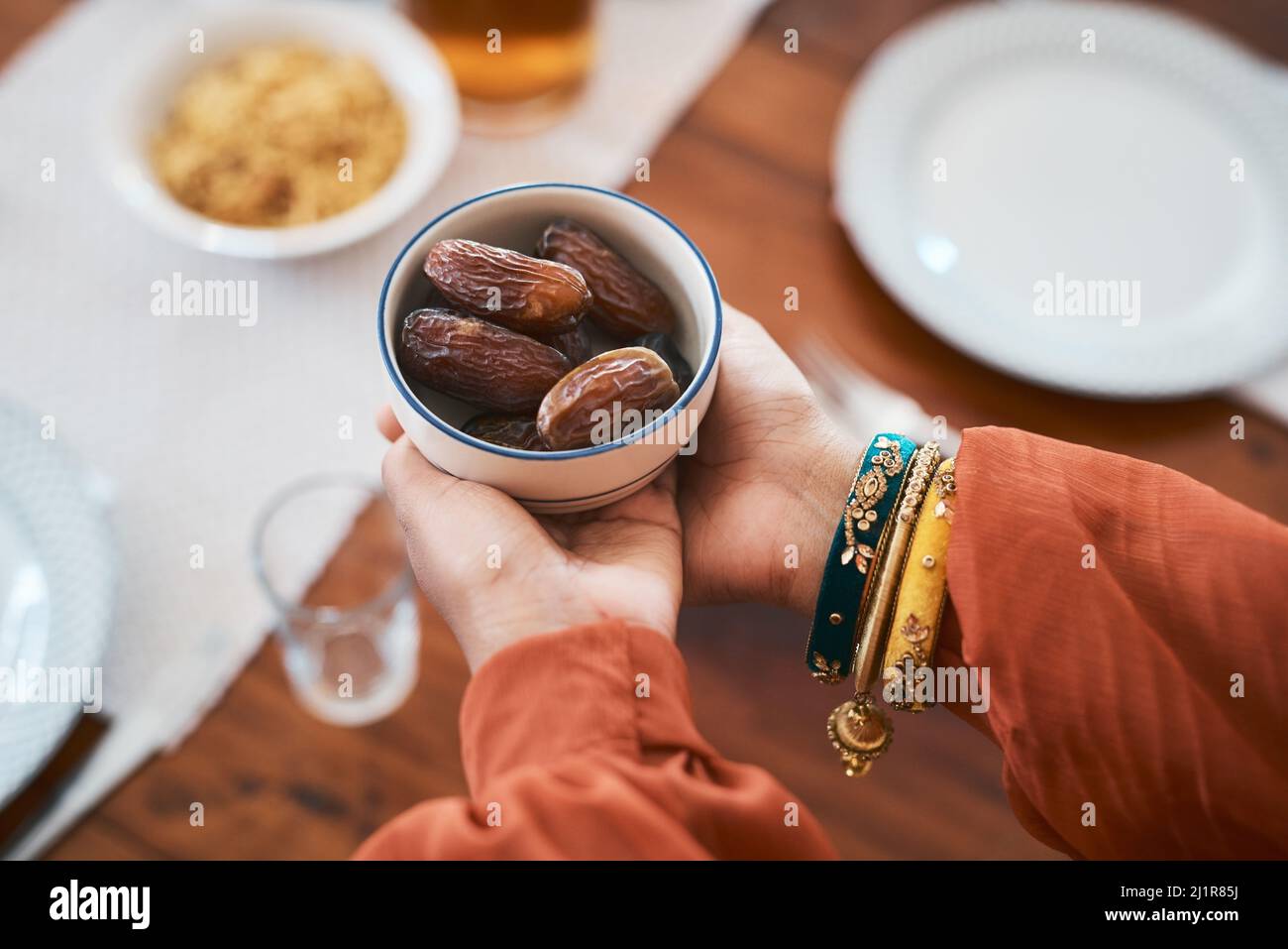 Briser ma vitesse de la manière traditionnelle. Prise de vue d'une femme musulmane tenant un bol de dates pour la briser rapidement. Banque D'Images