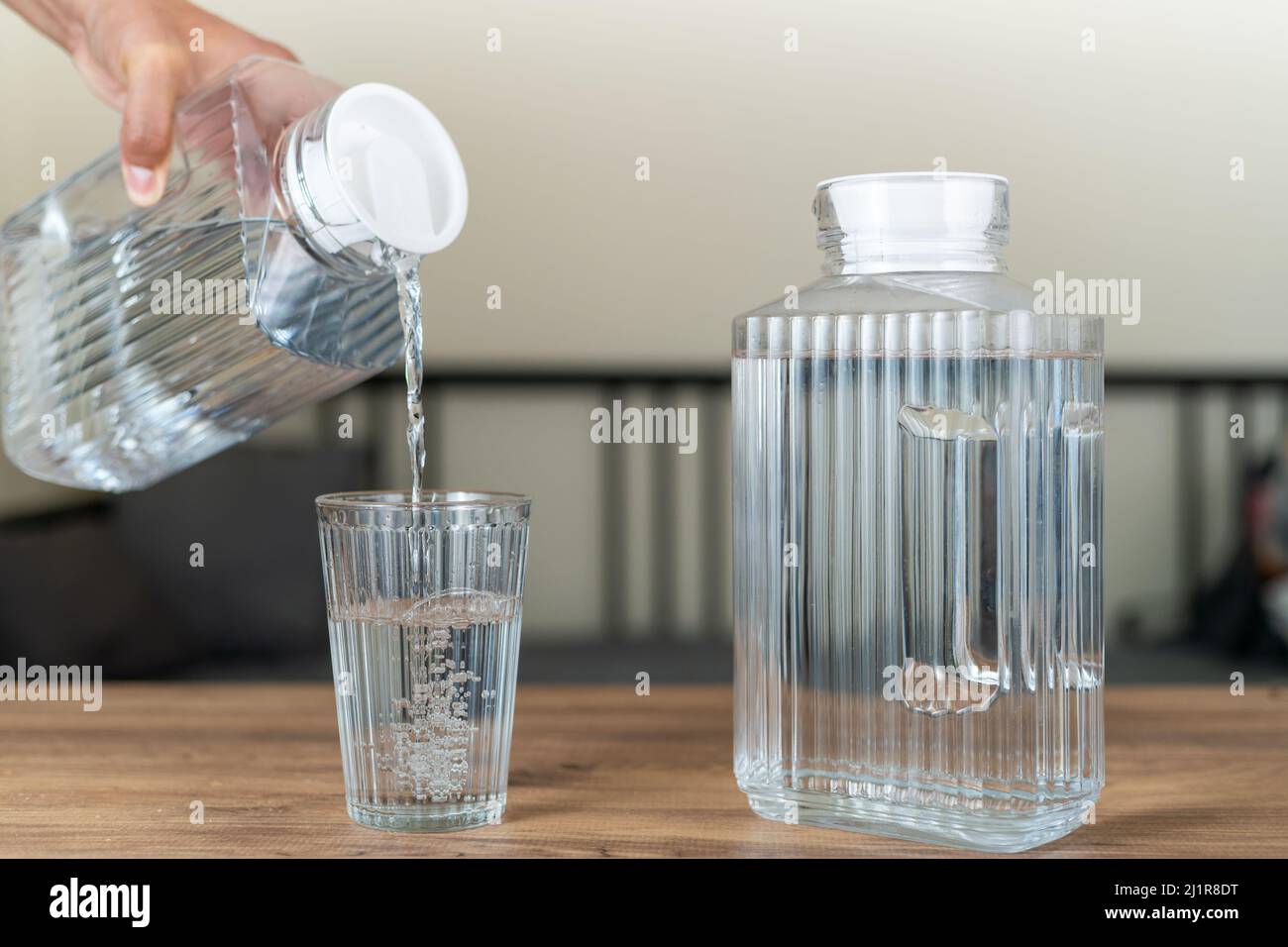 Verser à la main de l'eau propre et pure dans un verre. Banque D'Images