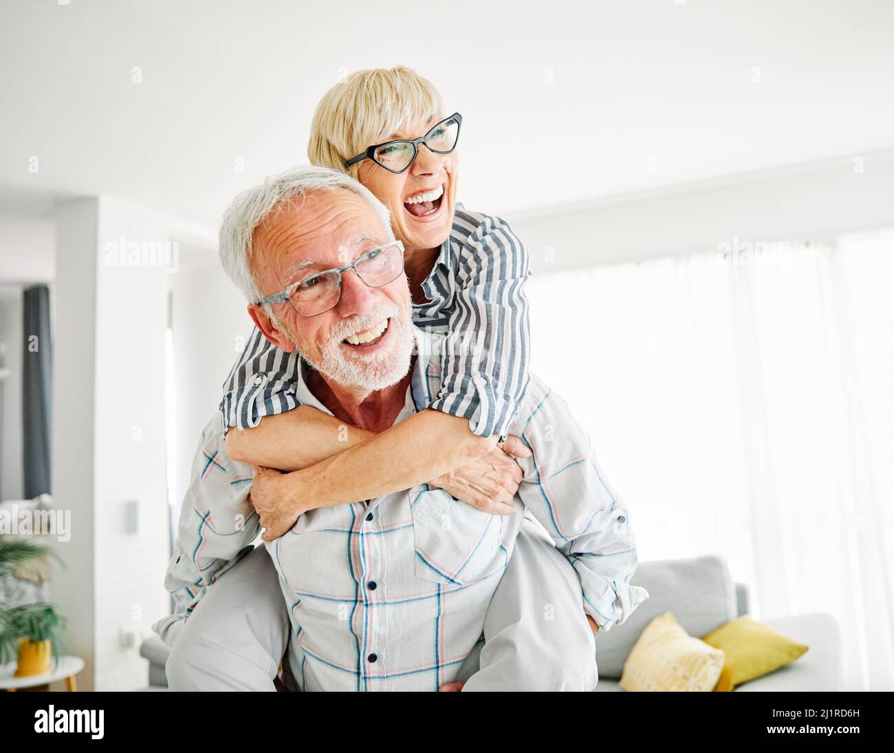 couple senior amour ensemble heureux hug maison famille vieux homme femme retraite sourire pigeyback Banque D'Images