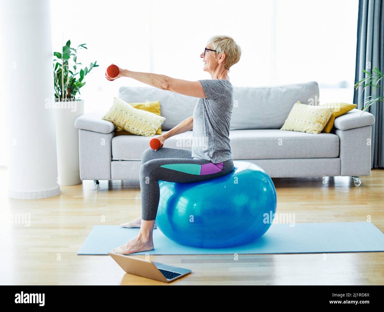 senior exercice intérieur femme entraînement style de vie sport fitness maison saine gym exercice fitness ordinateur portable Banque D'Images