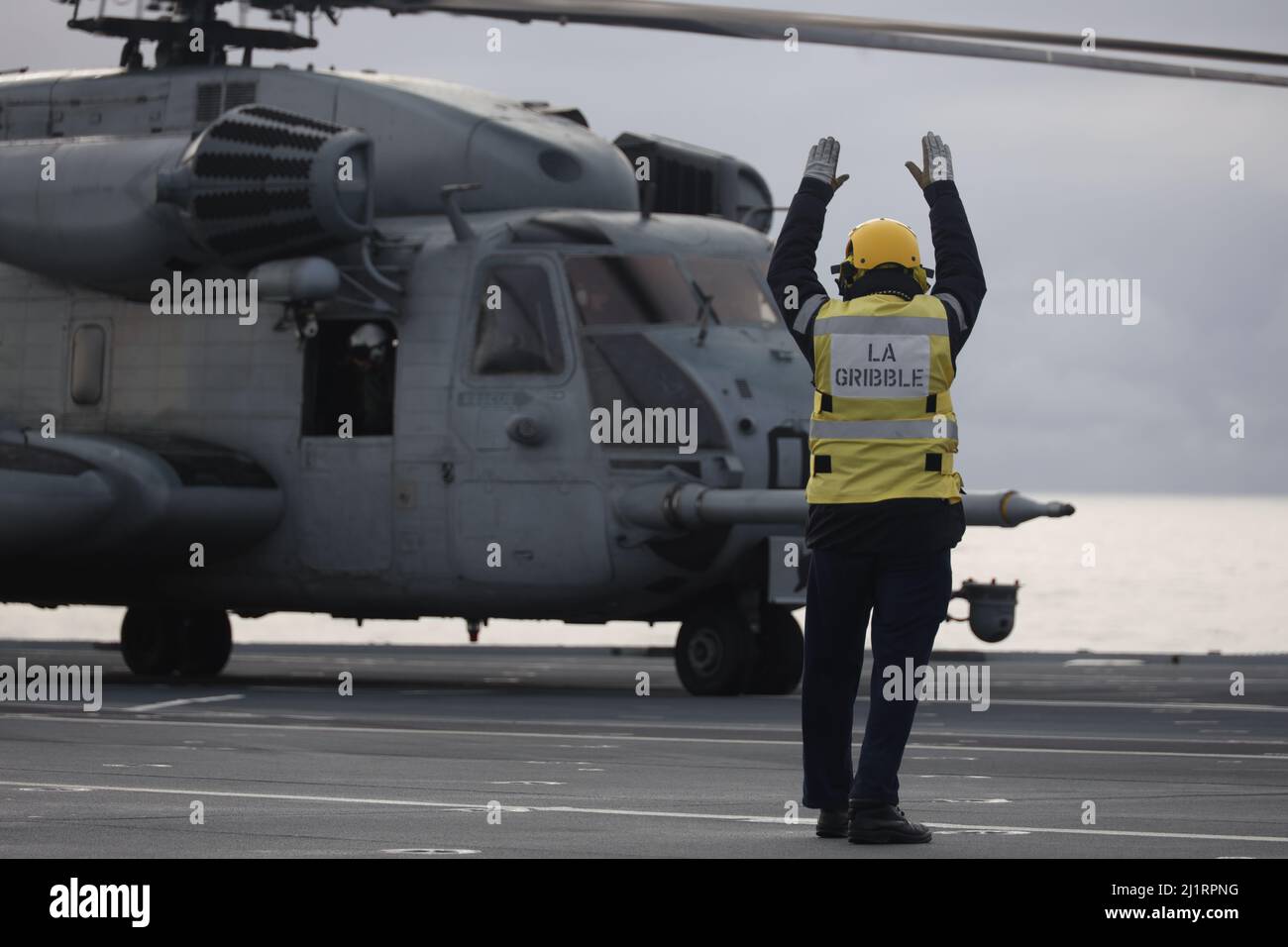 Un marin de la Marine royale du Royaume-Uni signale qu'un Super Stallion CH-53E détiendra pendant l'exercice Cold Response 2022, Mer norvégienne, 24 mars 2022. Le CH-53E Super Stallion est affecté au Marine Heavy Helicopter Squadron 366, Marine Aircraft Group 29, 2D Marine Aircraft Wing. L'exercice Cold Response '22 est un exercice biennal de préparation nationale et de défense norvégien qui a lieu dans toute la Norvège, avec la participation de chacun de ses services militaires, ainsi que de 26 autres nations alliées de l'OTAN et partenaires régionaux. (É.-U. Photo du corps marin par Sgt. Jonathon Wiederhold) Banque D'Images