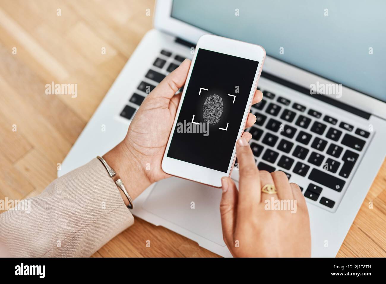 La reconnaissance des empreintes digitales est la voie à suivre. Photo d'une femme d'affaires méconnue utilisant un téléphone portable et un ordinateur portable dans son bureau. Banque D'Images