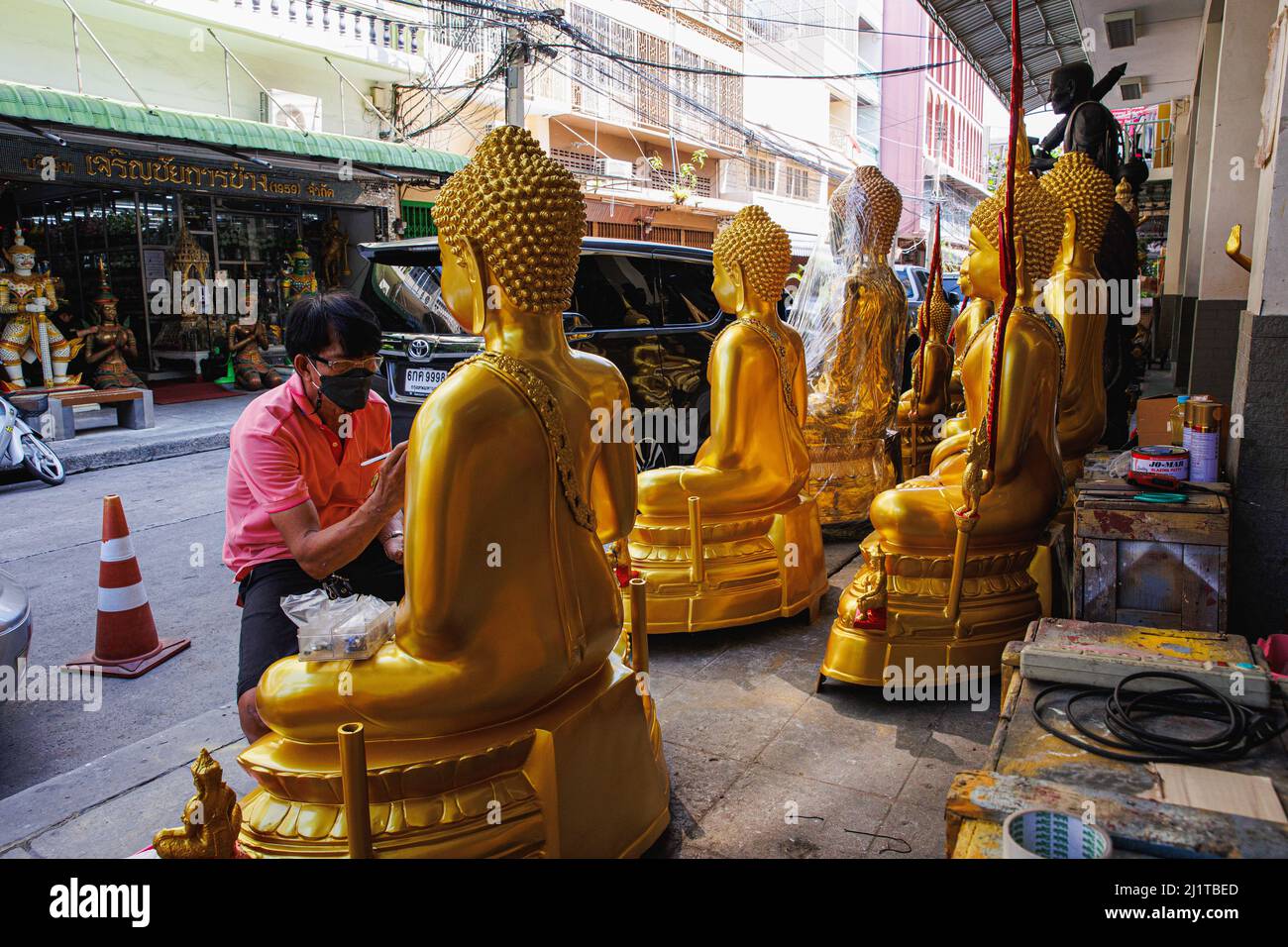 Un artisan a vu décorer une statue de bouddha dans la zone intérieure de Bangkok. L'île de Rattanakosin, dans la zone intérieure de Bangkok, est le cœur de la zone historique et culturelle de Bangkok. Cet endroit est également connu comme une vieille ville en raison des âges de la zone que plus de 100 ans d'existence. Non seulement palais, temples et monuments cette zone comprend la vie et les activités de l'homme qui vit autour de la zone sacrée de Bangkok. Banque D'Images