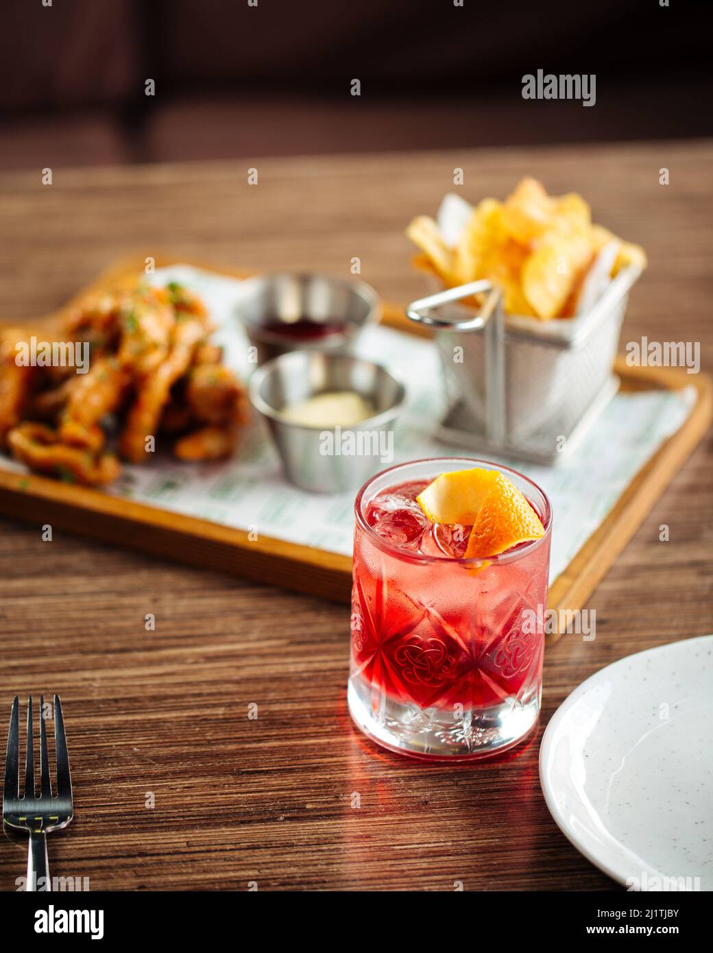 Cocktail rouge avec en-cas flou sur fond Banque D'Images