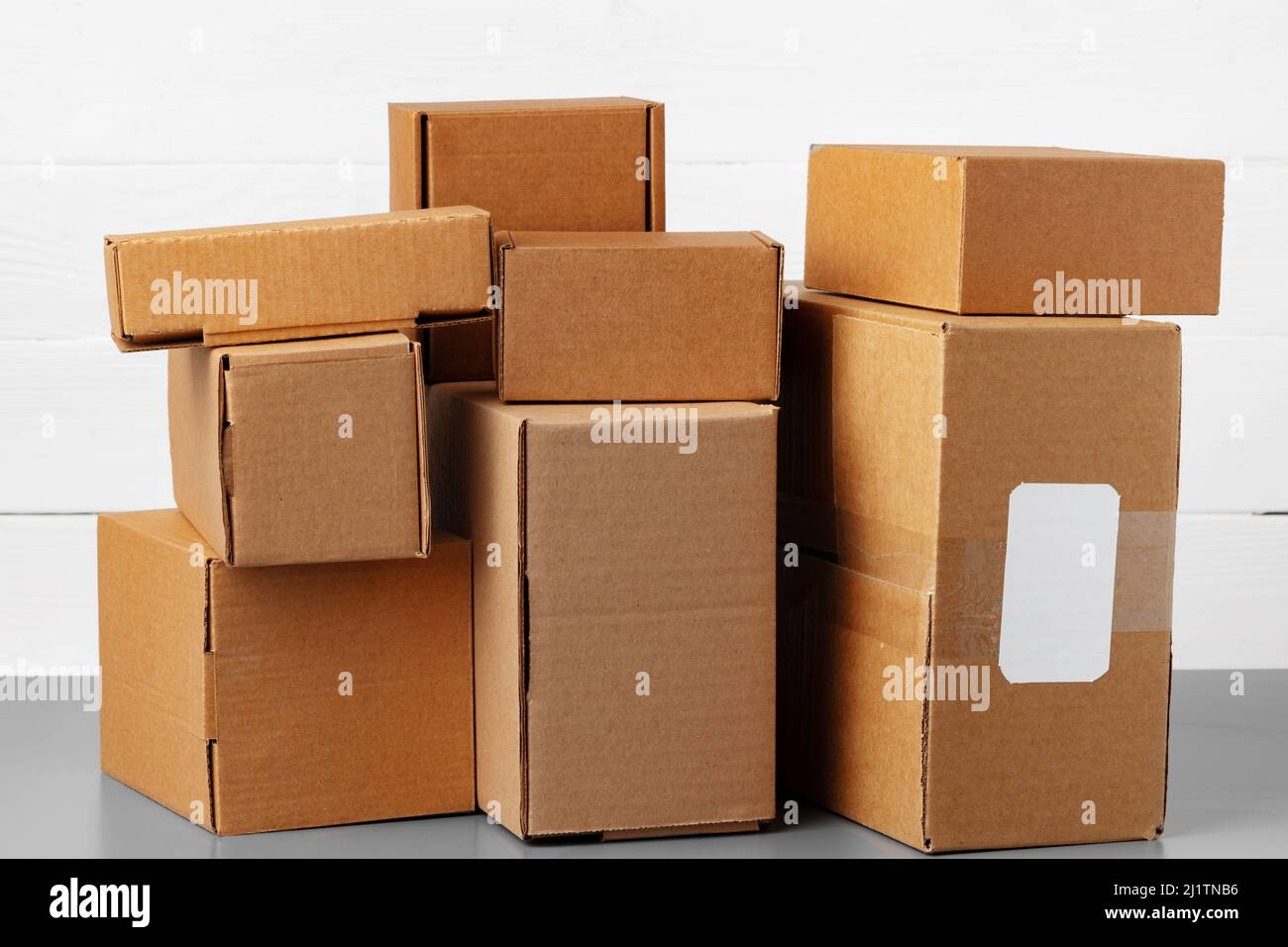 Groupe de boîtes en carton contre un mur en bois blanc Photo Stock - Alamy