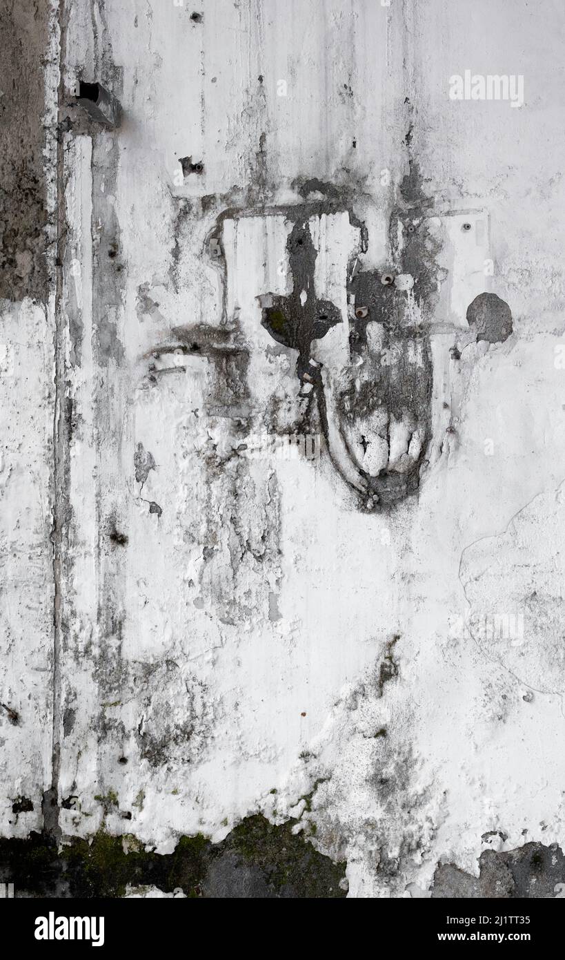 Mur en ciment blanc fissuré et écaillé avec un design abstrait naturel dans un moule noir. Banque D'Images