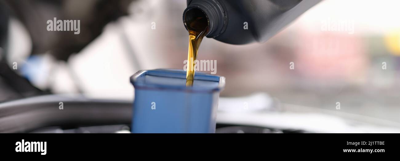 L'huile de machine pour une voiture est versée dans un récipient Banque D'Images