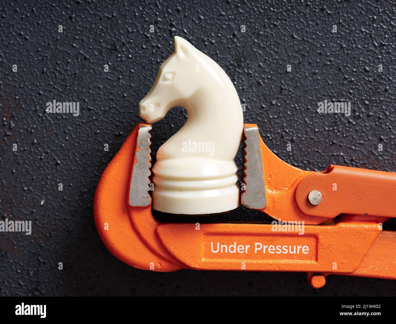 Le chevalier de pièce d'échecs est coincé dans la clé avec le mot sous pression. Stress, contrainte d'échéance, tension personnelle ou surcharge de travail. Banque D'Images